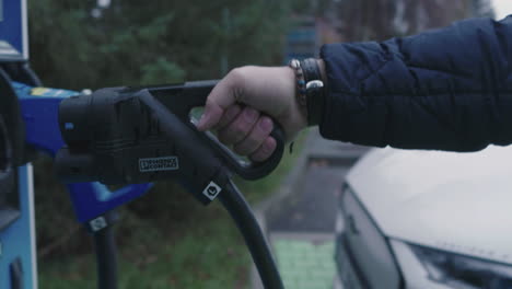 Hand-Taking-Plug-on-Charging-Station-For-Electric-Cars,-Close-Up