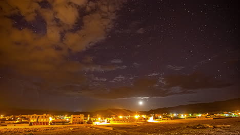 Time-lapse-of-sun-disappearing-into-starry-and-cloudy-sky-over-city-of-Morocco-illuminated-at-evening