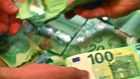 Dólares-Canadienses-Intercambiados-Por-Billetes-De-Euro-En-Una-Mesa-Cubierta-Con-Billetes-De-Veinte-Dólares,-Capturados-En-Un-Primer-Plano