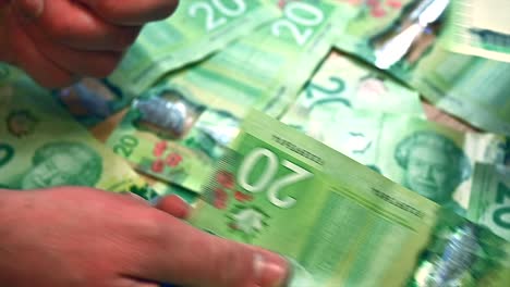 Euros-being-exchanged-for-Canadian-dollars-on-a-table-covered-in-twenty-dollar-bills,-captured-in-a-close-up-shot