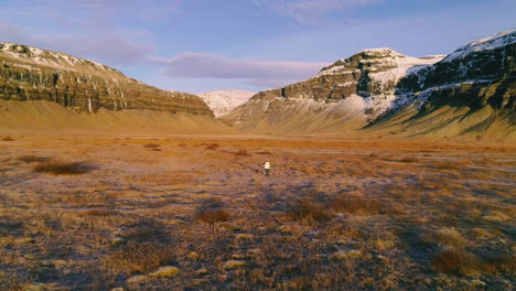 Aerial-view-following-females-Mýrdalshreppur-journey-towards-spacious-Icelandic-vast-mountain-landscape
