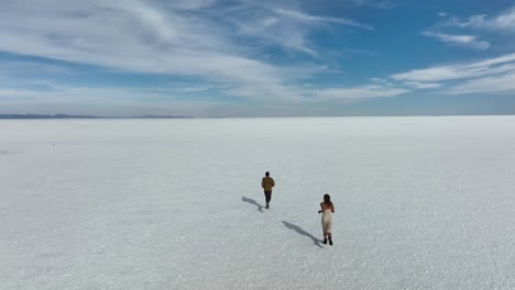 Uyuni,-Bolivia---Tourists-friends-running-alone-with-freedom-at-the-desertic-Salar-de-Uyuni-covered-with-water-and-salt-in-romantic-slow-motion