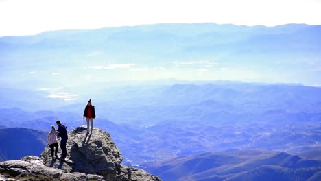 Almeria,-Spain,-December-14,-2022:-Group-of-friends-relaxing-and-posing-for-picture-above-a-rock-against-idyllic-view-of-mountain-range-high-at-Calar-alto-observatory,-in-Andalusia,-Spain