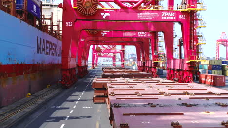 Aerial-drone-through-a-saddle-crane-in-Durban-harbour-with-a-container-cargo-ship-being-loaded