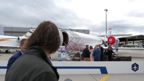 Private-jet-Dassault-Falcon-6X-on-display-at-EBACE-airport-exhibit,-slow-pan