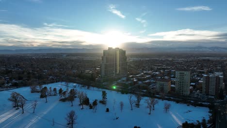 Aerial-tracking-shot-of-country-club-towers-Cherry-Creek-and-slowly-revealing-city-view-of-Denver-during-sunrise-and-mountain-view-at-the-backdrop,-Colorado