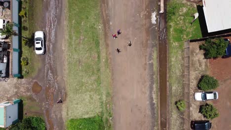 Drone-video-of-guys-walking-on-a-road-in-the-west-of-Harare,-Zimbabwe