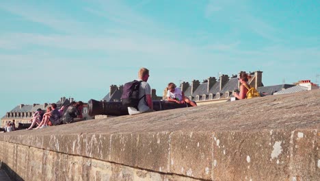 Una-Madre-Toma-Una-Foto-De-Su-Hijo-Sentado-En-Un-Canon-En-Las-Murallas-De-La-Ciudad-De-Saint-malo,-Bretaña,-Francia