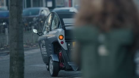 Mini-car-driving-off-on-to-the-street-in-Rotterdam,-The-Netherlands