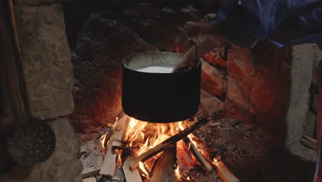 Traditional-Cheesemaking,-Hand-Stirs-Pot-Heated-Over-Fire,-Chobareti-Georgia