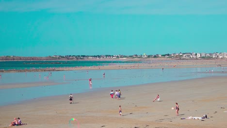 Gente-Disfrutando-De-Un-Día-En-La-Playa-Durante-La-Marea-Baja-En-Saint-malo,-Bretaña