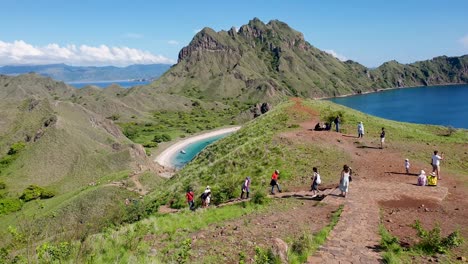 Turista-Explorando-La-Isla-Padar-Tropical-Deshabitada-Con-Vistas-Montañosas-Y-Turquesas-Al-Océano-Dentro-Del-Parque-Nacional-De-Komodo,-Isla-De-Flores,-Indonesia