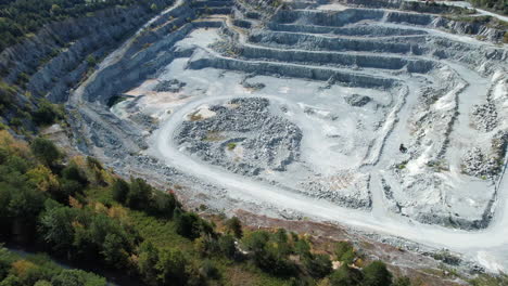Aerial-drone-over-an-open-pit-mine,-quarry