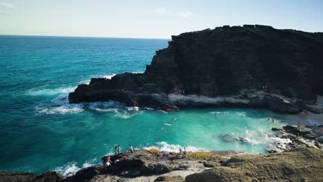 Menschen-Schwimmen-Und-Klippenspringen-Am-Halona-Blow-Hole,-Honolulu,-Hawaii-An-Einem-Hellen-Sonnigen-Tag-Im-Türkisblauen-Pazifischen-Ozean