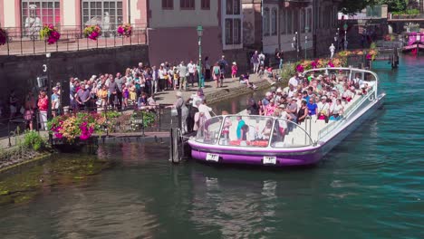 Passengers-disembark-a-sightseeing-boat-near-Pont-du-Corbeau,-Strasbourg,-Alsace,-France