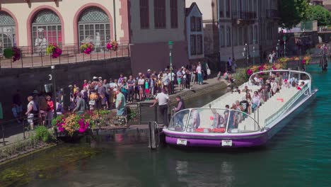 Passengers-disembark-a-half-empty-sightseeing-boat-near-Pont-du-Corbeau