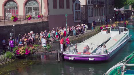 Passengers-board-an-empty-sightseeing-boat-near-Pont-du-Corbeau,-Strasbourg,-Alsace,-France