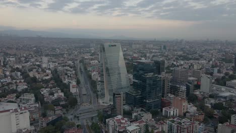 Drohne-Fliegt-über-Riesige-Gebäude-Mit-Einigen-Autos,-Die-An-Bewölkten-Tagen-In-Mexiko-Stadt-Fahren---Filmmaterial