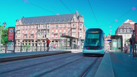 Eine-Straßenbahn,-Die-Von-Einer-Haltestelle-Am-Pont-Royal-In-Der-Nähe-Der-Universitätsresidenz-Gallia,-Straßburg,-Elsass,-Frankreich,-Abfährt