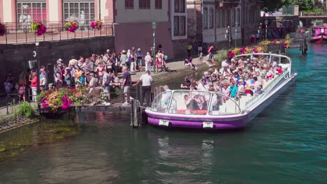 Passengers-disembark-a-sightseeing-boat-near-Pont-du-Corbeau,-Strasbourg