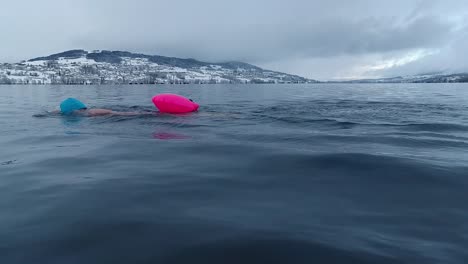 Woman-swimming-in-a-lake-in-Switzerland-in-winter