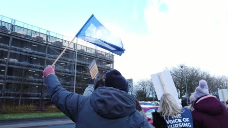 NHS-nurses-strike,-waving-banners-and-flags-demand-for-fair-pay-and-better-patient-care