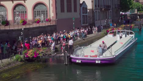 Passengers-disembark-a-half-empty-sightseeing-boat-near-Pont-du-Corbeau