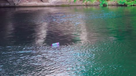 Eine-Leere-Plastikflasche-Schwimmt-Auf-Wasser-In-Einem-Kanal