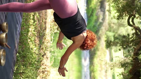 Mujer-De-Tiro-Vertical-Posando-En-Yoga-Estirando-Los-Brazos-En-Una-Naturaleza-Pacífica