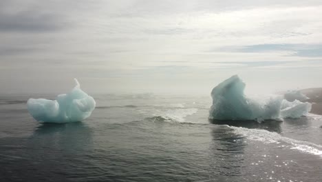 Icebergs-En-La-Playa-De-Diamantes-En-El-Sureste-De-Islandia,-Carro-Aéreo-Bajo-En