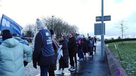 NHS-nurses-service-strike,-waving-banners-and-flags-demanding-fair-pay-and-better-patient-care