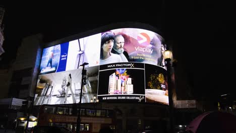 Piccadilly-Circus-screen-in-London-at-night-with-people-walking-and-busy-traffic