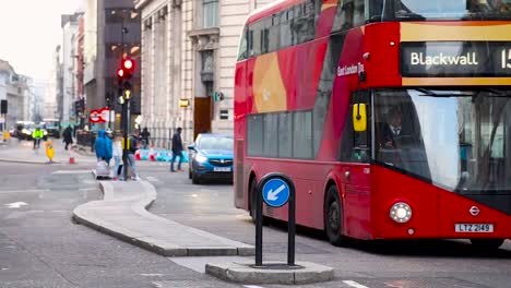 Londinenses-Cruzando-La-Calle-Eastcheap-Por-Monumento,-Concurrida-Escena-Urbana-Con-Autobuses-Rojos-Pasando