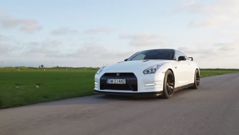 Driving-white-Nissan-GTR-sports-car-on-rural-road