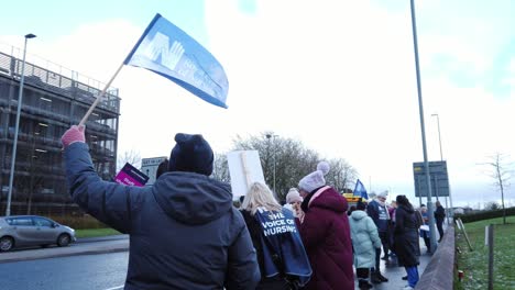 NHS-nurses-strike,-waving-their-banners-and-flags-demanding-fair-pay-and-better-patient-care