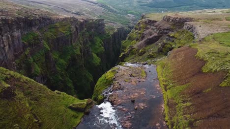 Glymur-waterfall-from-top-with-birds-flying-in-ravine,-Iceland,-aerial-view