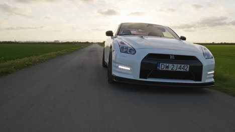 Powerful-Nissan-GTR-sports-car-drive-countryside-road-at-sunset