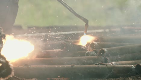 Torcher-cutting-metal-in-slow-motion-at-a-scrapyard,-big-power-tools-120fps