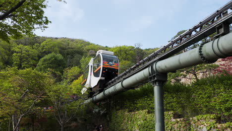 Tren-Monorraíl-Con-Viajeros-Que-Se-Desplazan-Por-Las-Vías-Del-Tren-A-Través-Del-Jardín-Botánico-De-Hwadam-O-Hwadamsup-En-Primavera