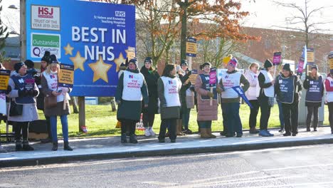 UK-hospital-nurses-protest-demonstration-for-fair-pay,-holding-banners-and-flags-on-strike