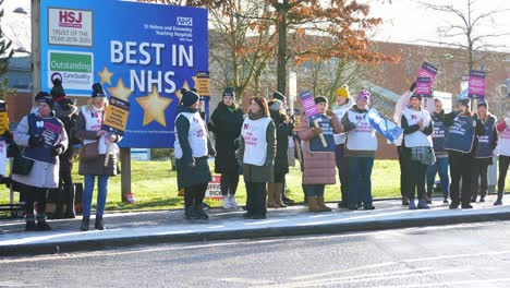 UK-hospital-nurses-protest-for-fair-pay,-holding-banners-and-flags-on-public-strike
