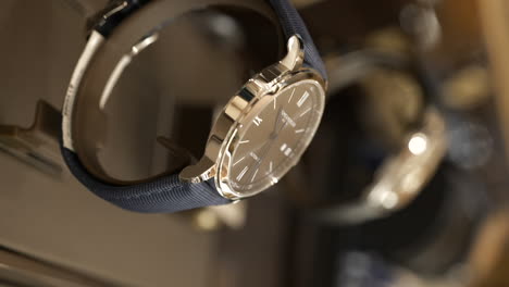 VERTICAL-Macro-side-view-of-Baume-Mercier-luxury-watches-on-display-in-jewellery-store-glass-counter