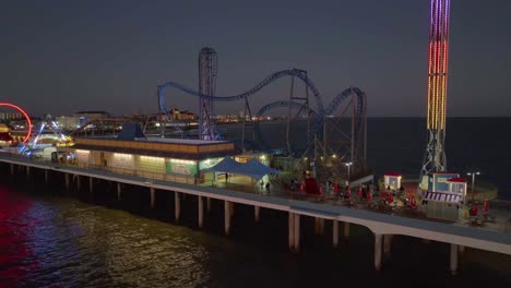 Drohne-Schoss-In-Der-Nähe-Von-Fahrgeschäften-Im-Vergnügungspark-Am-Historischen-Vergnügungssteg-Von-Galveston-Island,-Dämmerung-In-Texas,-Usa