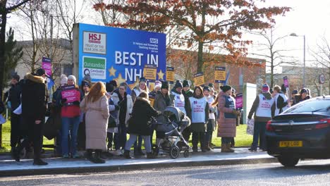 Nhs-krankenschwestern-Streiken-An-Einem-Kalten-Wintermorgen-Für-Faire-Entlohnung-Und-Bessere-Versorgung-Im-St-Helens-Hospital-Und-Schwenken-Banner-Und-Fahnen