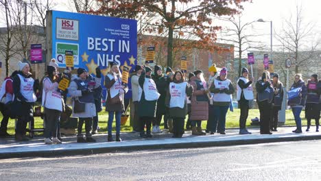 UK-hospital-nurses-protest-in-unity-for-fair-pay,-holding-banners-and-flags-on-strike