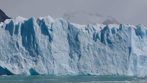 Meisterhafte-Aufnahme-Eines-Blauen-Gletschers,-Umgeben-Von-Nebel-Und-Einem-Angrenzenden-Berg