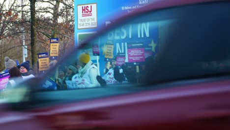 UK-hospital-nurses-protest-for-fair-pay-action,-holding-banners-and-flags-on-strike