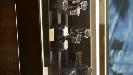 Grupo-Vertical-De-Relojes-De-Lujo-Baume-Mercier-En-Exhibición-Para-La-Venta-En-El-Mostrador-De-Cristal-De-La-Joyería