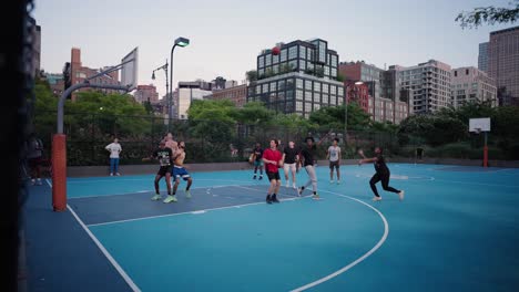 People-playing-basketball-in-slomo,-westside-highway-courts-Manhattan,-NY