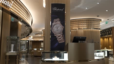 Inside-expensive-Barcelona-jewellery-store-with-elegant-Chopard-watch-advertisement-behind-counter